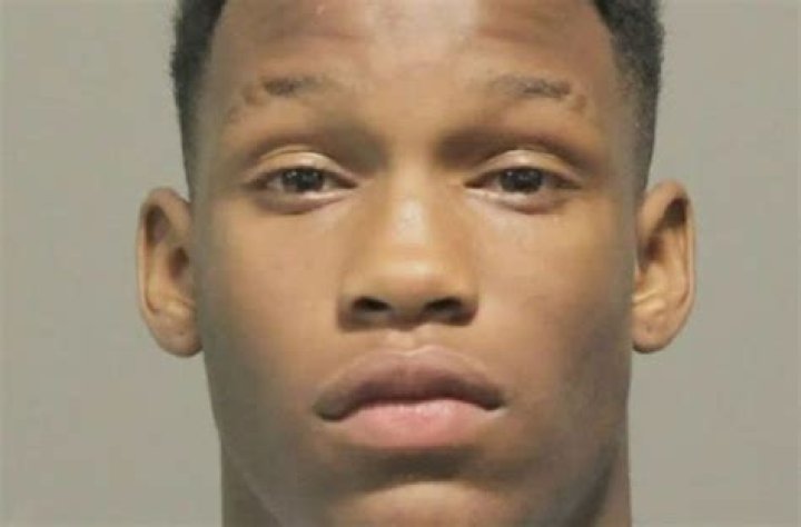 Marcus Cooper Jr. doesn't look happy in the picture as he is standing in front of a grey background.